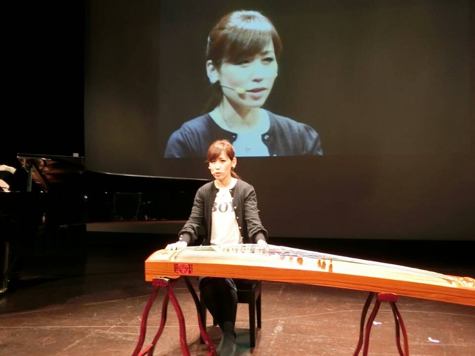 セミナーで古箏を演奏する王敏(スクリーン投影)